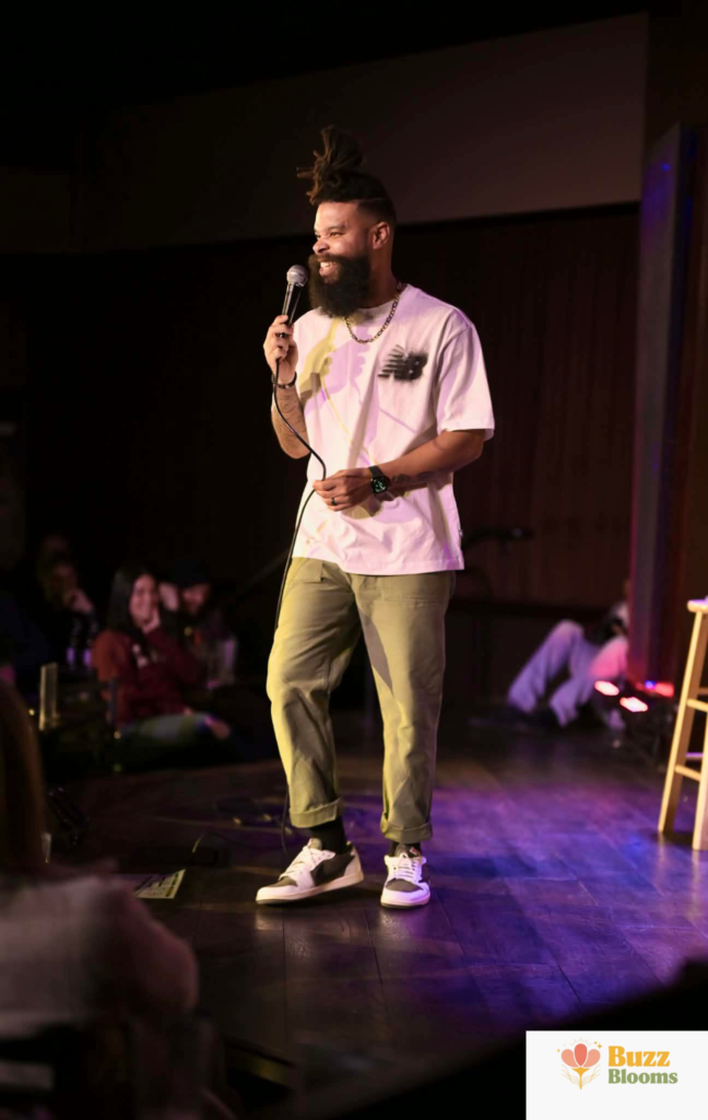 Damon Darling performing live comedy on stage, crowd visible
